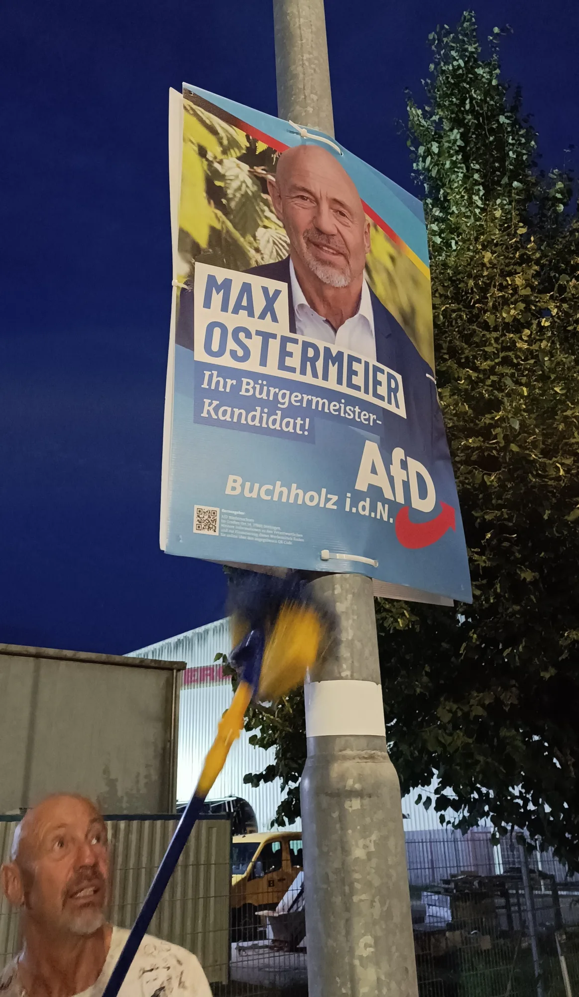 Wahlplakat von Max Ostermeier wird am Mast befestigt